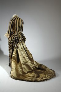 Robe de soirée, vers 1884 (vue oblique arrière). Satin de soie et velours coupé, dentelle, glands et franges en fil de soie. Charles Frederick Worth, France.