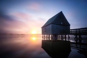 Lever de soleil sur le hangar à bateaux brumeux - Christoph Schaarschmidt