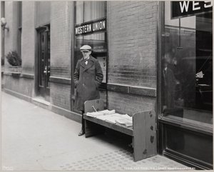 Le marchand de journaux aveugle, Frederick Rode, et le coin sud-est de Broadway et de la 41e Rue. Une enseigne Western Union est visible dans la fenêtre derrière M. Rode