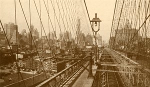 Lower Manhattan vu à travers le réseau de câbles sur le pont suspendu de Brooklyn, vers 1930 - ENA