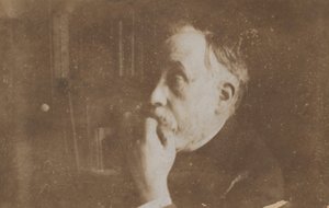Autoportrait dans la bibliothèque, main au menton
