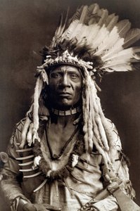 Queue de belette (Apohsuyis). Portrait du chef indien de la tribu Piegan portant la célèbre coiffe en plumes d