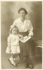 Jolie fille, mère ou gouvernante, montrant des photos à un jeune enfant - English Photographer