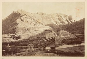 Vues sur le chemin de fer du Pacifique, de la voie ferrée traversant une rivière sur un pont en treillis, avec des montagnes au-delà