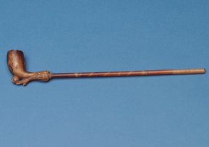 Pipe avec tige en bambou et botte sculptée frappant un ballon en dessous - English School