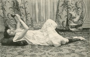 Fille, allongée sur le sol, tenant une balle au-dessus de sa tête