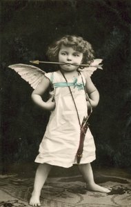 Petit garçon, déguisé en Cupidon, avec une flèche dans la bouche