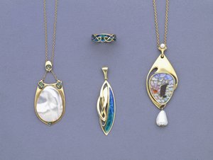 Un groupe de pendentifs en métal jaune et émail de Liberty & Co et une bague conçue par Archibald Knox