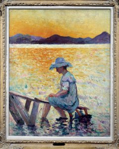 Saint-Tropez, coucher de soleil. Une femme assise les pieds dans l
