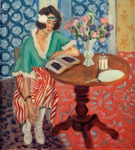 Femme lisant à une table (en robe rayée verte et rouge)