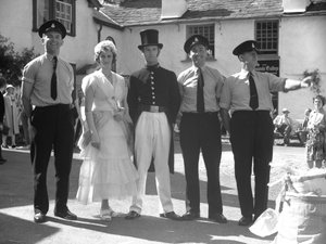 Hommes et femmes déguisés à la foire de Hawkshead devant le Mintrel