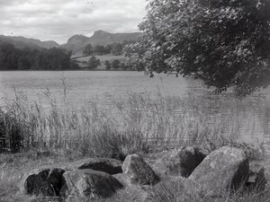 Vue sur le Tarn de Loughrigg, au premier plan, quelques pierres enfoncées dans le sol.
