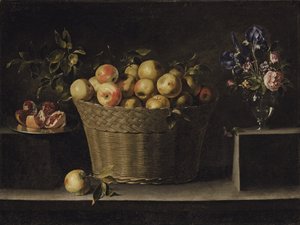 Pommes dans un panier en osier, une grenade sur une assiette en argent et des fleurs dans un vase en verre