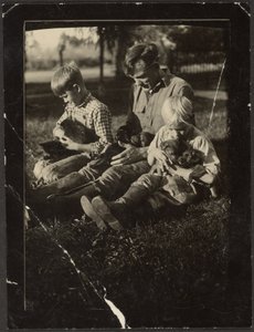 [Homme avec enfants et chiots dans la cour]