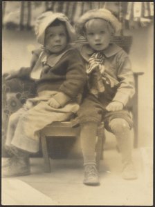 [Deux enfants partageant la même chaise]