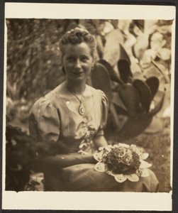 [Femme tenant un bouquet, assise devant un cactus]
