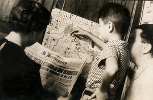 Une femme lit la première page du journal The Messenger avec le titre "The Tricolour waving victorious of Adwa recaptured" (Le Tricolore flottant victorieux d