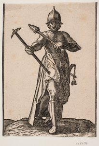 Soldat casqué debout, vu de face; dans la main droite un marteau de guerre, dans la main gauche une massue, la jambe et le pied arrière tordus par rapport à l