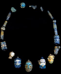 Collier en pâte de verre avec pendentifs représentant des têtes barbus, originaire d