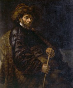 Un homme assis avec un bâton