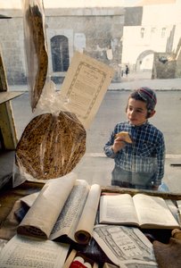 Garçon juif conservateur mangeant un gâteau regarde dans une librairie religieuse