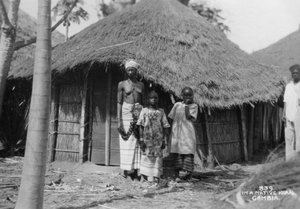 Une famille devant leur maison, Gambie, 20e siècle