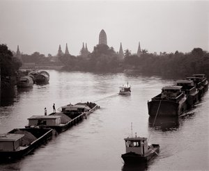 Péniches descendant la rivière Chao Phraya avec vue sur Wat Chaiwatthanaram