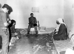 Saddam Hussein visitant une maison paysanne à Bassora, Irak