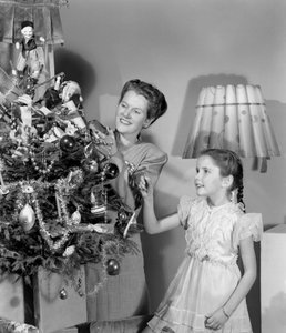 Femme et fille décorant un arbre de Noël, vers 1948