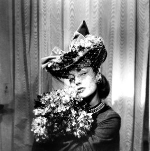 Femme portant un chapeau avec un voile, tenant un bouquet de fleurs, Paris, 1943 - Unbekannt