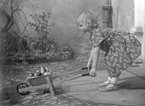 Petite fille jouant avec une brouette. Photographie vers 1931 - Unbekannt