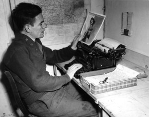 Seconde Guerre mondiale (1939-1945) : Mutzig (Alsace) France 1 décembre 1944 : Le caporal Flanerty chroniqueur du Beachead News (journal des GI) regarde une photographie de pin-up qu