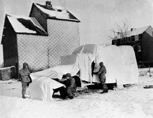 Seconde Guerre mondiale (1939-1945) : Près de Bastogne (Belgique) fin décembre 1944 : Ces soldats américains utilisent des draps blancs pour dissimuler un camion aux yeux de l