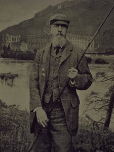 Portrait en studio du 8e duc de Devonshire en tweed tenant une canne à pêche devant un écran imprimé représentant Chatsworth - William M. Timlin