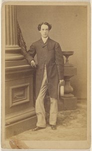 [Homme non identifié portant des gants, tenant un chapeau de paille dans sa main gauche, debout].