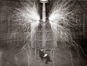 Nikola Tesla assis dans son laboratoire de Colorado Springs avec son « Transmetteur amplifiant »