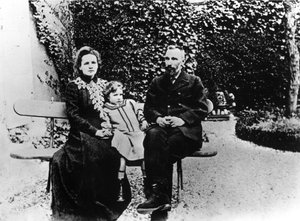 Pierre (1859-1906) et Marie Curie (1867-1934) assis sur un banc dans un jardin