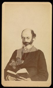 [Homme non identifié, chauve et barbu, lisant assis].