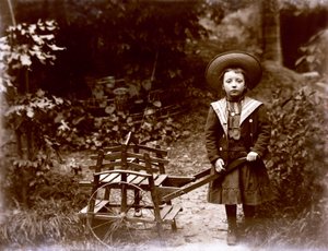 Fille avec une charrette dans un jardin, début du 20ème siècle - . .