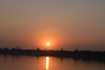 Reflets dorés du coucher de soleil sur une rivière paisible - Albert Mansour