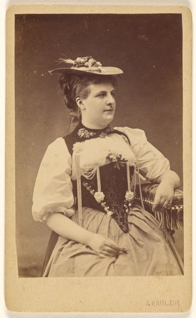[Femme non identifiée en costume indigène avec chapeau, assise]. - A. Gabler