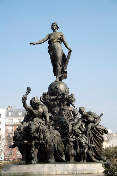 Le char de la nation ou triomphe de la République. Symbole du suffrage universel. Debout sur un char tiré par deux lions (symbole de la force populaire), Marianne est entourée des allégories du Travail, de la Justice, de la Paix et de l