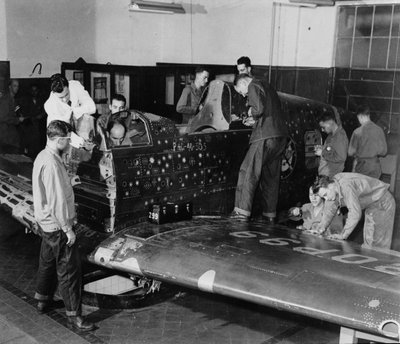 Des soldats en formation travaillent sur un "Flying Patch," un avion de chasse Curtiss "Warhawk" sans moteur ni assemblage de queue, avec des trous de balles simulés et des patchs, vers 1942 - American Photographer