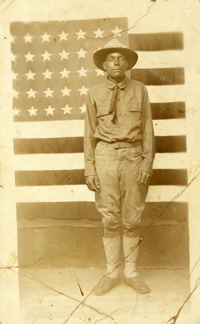 Soldat de la Première Guerre mondiale avec drapeau américain en arrière-plan, 1914-18 - American Photographer