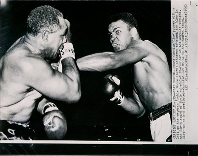 Le Jeune Cassius Clay marque un point avec un gauche contre le vétéran Archie Moore au premier round du combat à Los Angeles - American Photographer