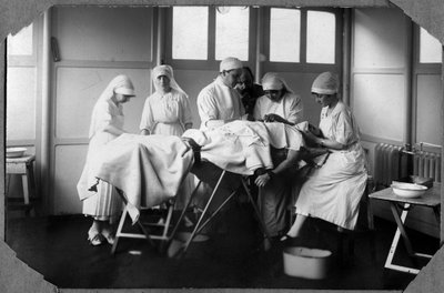 Première Guerre mondiale 1914-1918 : médecins et infirmières de la Croix-Rouge (Thérèse Pavillou ?) soignant un soldat endormi sous chloroforme dans le camp de Couville dans la Manche, Basse-Normandie, France. Photographie anonyme. - Anonymous Anonymous