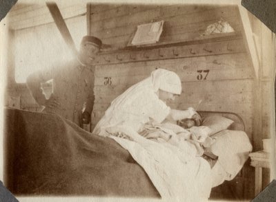 Première Guerre mondiale 1914-1918 : infirmière en blouse rasant un soldat (blessé de guerre français allongé dans un lit), à Couville, Manche, Basse-Normandie, France. Photographie anonyme juillet 1917. Collection privée, Stella. - Anonymous Anonymous