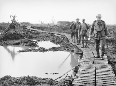 Quatre soldats australiens marchant le long de la piste de caillebotis à Tokio, près de Zonnebeke, dans le secteur d