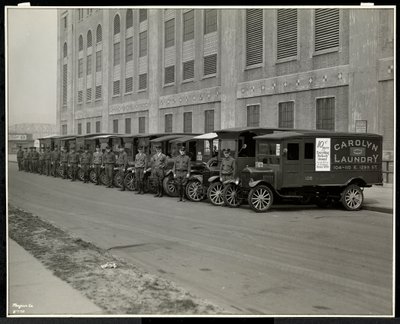 Une ligne de camions de livraison garés devant la blanchisserie Carolyn au 111 East 128th Street, East Harlem, New York, 1929 - Byron Company