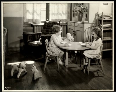 Deux filles aveugles ou malvoyantes mangeant à une petite table avec une poupée à l